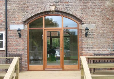 Timber arched glazed door in period barn conversion
